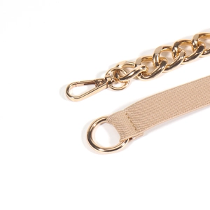 Macro detail of golden metal chain with lobster clasp and khaki elastic belt strap