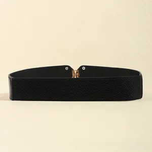 Gros plan détaillé d'une large ceinture élastique noire avec un fermoir en métal doré