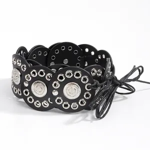 Detail of bohemian black leather waist belt with silver metal discs and eyelet studs