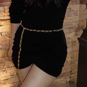 Détail d'une ceinture chaîne dorée à trombones sur une robe noire pour femme