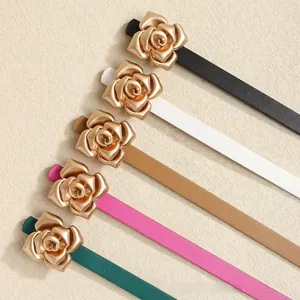 Detail view of five skinny belts in various colors with golden rose buckles and leather texture