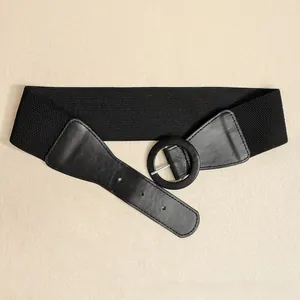 Detail of black elastic wide waist belt with round buckle and faux leather trim