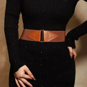 Nahaufnahme eines braunen elastischen Taillengürtels mit Lederdetails auf einem schwarzen Kleid
