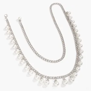 Detail of silver metal chain waist belt with glossy white pearls and lobster clasp