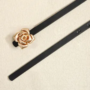 Close-up of a women's slim black leather belt featuring a detailed gold rose metal buckle