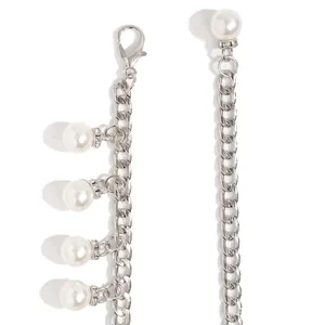 Detail of silver chain belt with white faux pearls and rhinestone-encrusted spacers