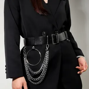 Punk style wide black leather belt with silver metal rings and multi-layer chains on a suit