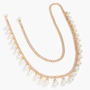 Detail of elegant gold metal chain with white pearl tassels and lobster clasp closure