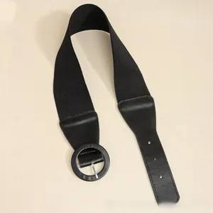 Detail view of stylish black wide elastic waist belt with high-stretch band and round pin buckle