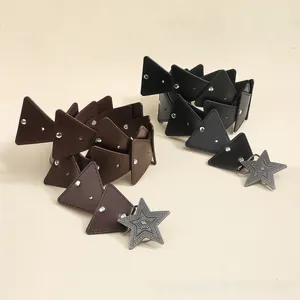 Macro detail of Bohemian star buckle and geometric triangle leather patchwork on belts