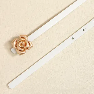 Detail of elegant white slim belt with a textured golden rose flower buckle design
