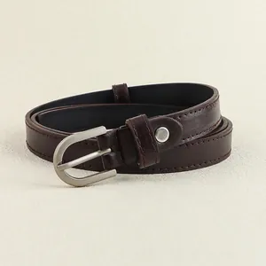 Gros plan détaillé d'une ceinture en cuir marron foncé avec boucle argentée en forme de D