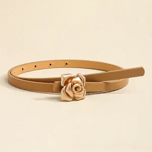 Macro shot of stylish gold rose buckle detail on elegant camel leather skinny waist belt