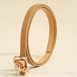 Detailed macro view of the 3D metal rose buckle and textured slim faux leather belt
