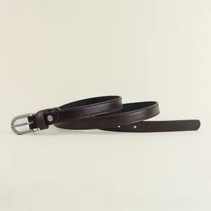 Détail de ceinture fine en cuir marron foncé avec boucle en D argentée et surpiqûres