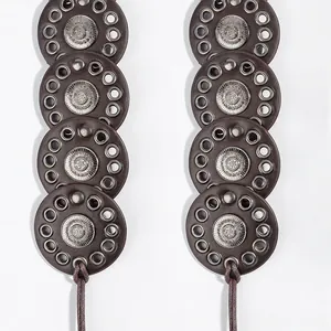 Detail of bohemian belt featuring embossed silver discs on dark brown leather plates