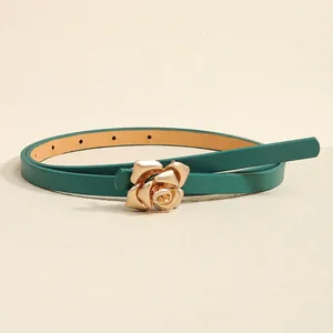 Detailed macro view of green leather belt featuring a golden 3D rose buckle