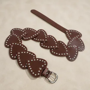 Vue détaillée d'une ceinture en cuir marron avec coeurs cloutés et boucle fer à cheval