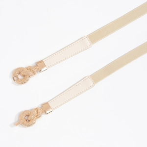 Detail of elegant beige elastic braided waist belts with golden intertwined knot buckles