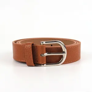 Détail d'une ceinture en cuir marron à texture litchi avec boucle en métal argenté en D