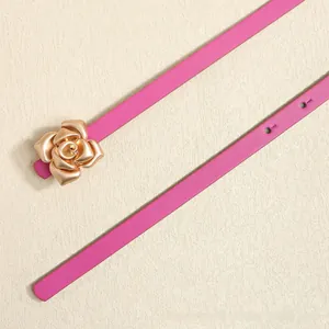 Detail of pink slim belt featuring a gold rose buckle and fine leather texture