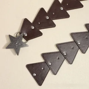 Detailed macro shot of vintage brown leather belt with star buckle and rivet studs