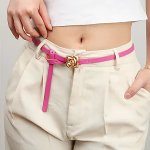 Detailed view of women's pink leather belt featuring a 3D golden rose metal snap buckle