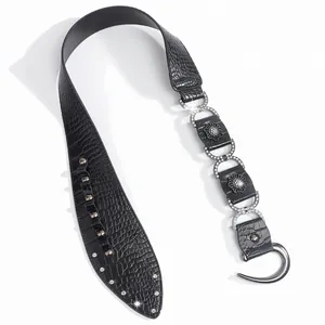 Détail de ceinture noire à texture croco avec boucles florales en métal et strass