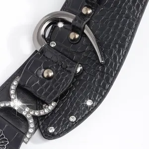 Détails de la ceinture noire motif crocodile avec boucle fer à cheval ornée de strass brillants