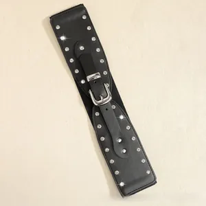 Détail d'une ceinture en similicuir noir avec boucle argentée et deux rangées de strass