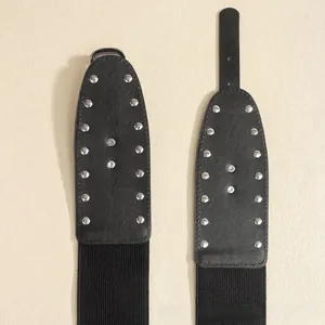 Détail d'une ceinture punk élastique noire avec clous métalliques argentés sur similicuir de luxe
