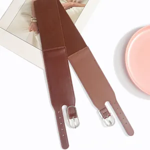 Détail de la ceinture élastique large avec boucle ardillon argentée et cuir marron foncé