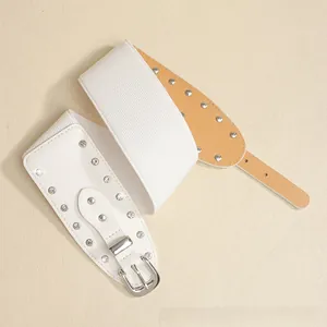 Détail d'une ceinture élastique blanche avec clous argentés et strass brillants
