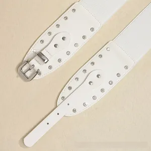 Détails de deux ceintures punk blanches ornées de strass brillants et de boucles argentées