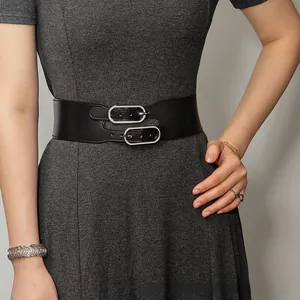 Détail d'une large ceinture élastique noire avec doubles boucles argentées sur robe