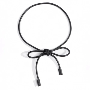 Detail view of a minimalist black knotted rope belt with decorative cylindrical end caps
