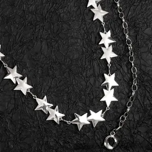Close-up of silver star chain belt with polished metal charms and adjustable clasp