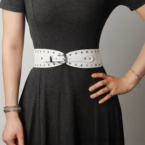 Détail d'une ceinture punk blanche à rivets argentés portée sur une robe