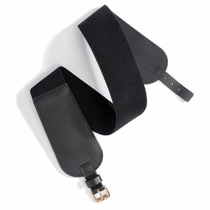Détail d'une ceinture élastique noire avec une boucle en métal doré et patchs en cuir