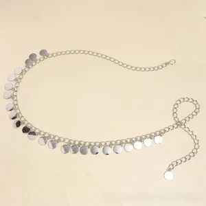 Détail d'une ceinture chaîne argentée ajustable avec pendentifs ronds en métal sur sable