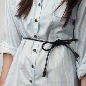 Detail of a black knotted waist rope belt on a blue striped shirt dress with copper buttons
