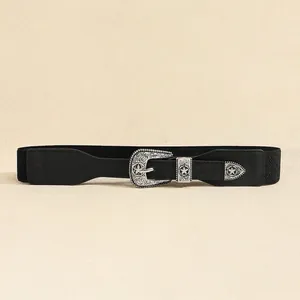 Detail of western vintage carved buckle and star motif on black elastic waist belt