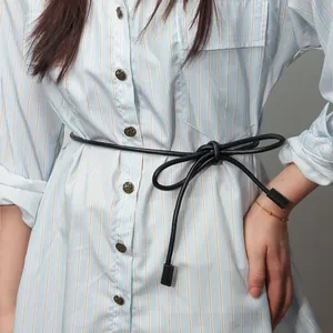 Close-up of black knotted waist rope styled on a blue and white striped shirt