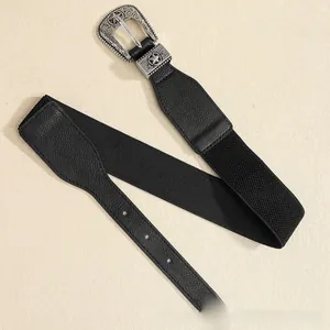 Detail of silver vintage carved buckle and star motif on black elastic fashion belt