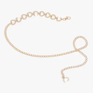 Détail d'une chaîne de taille dorée avec maillons en cœur et strass brillants
