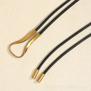 Détail de ceinture tressée bohème avec boucle en métal doré et embouts cylindriques