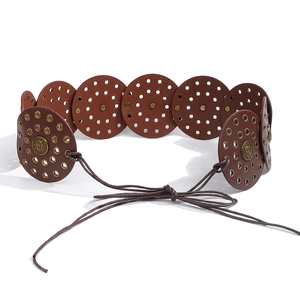 Detail of bohemian brown leather belt with round metal studs and lace-up cord closure