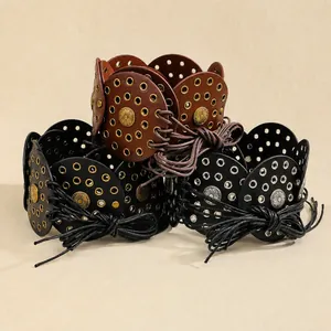 Detail of bohemian leather belts with sunflower metal studs and braided cord tie