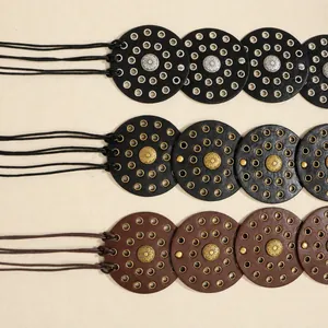 Detail of bohemian studded belts featuring circular panels with sunflower metal medallions