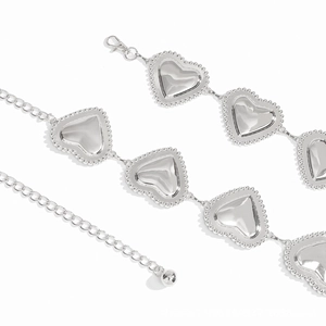 Détail de la ceinture chaîne en cœur argenté avec surface polie et bordure pointillée